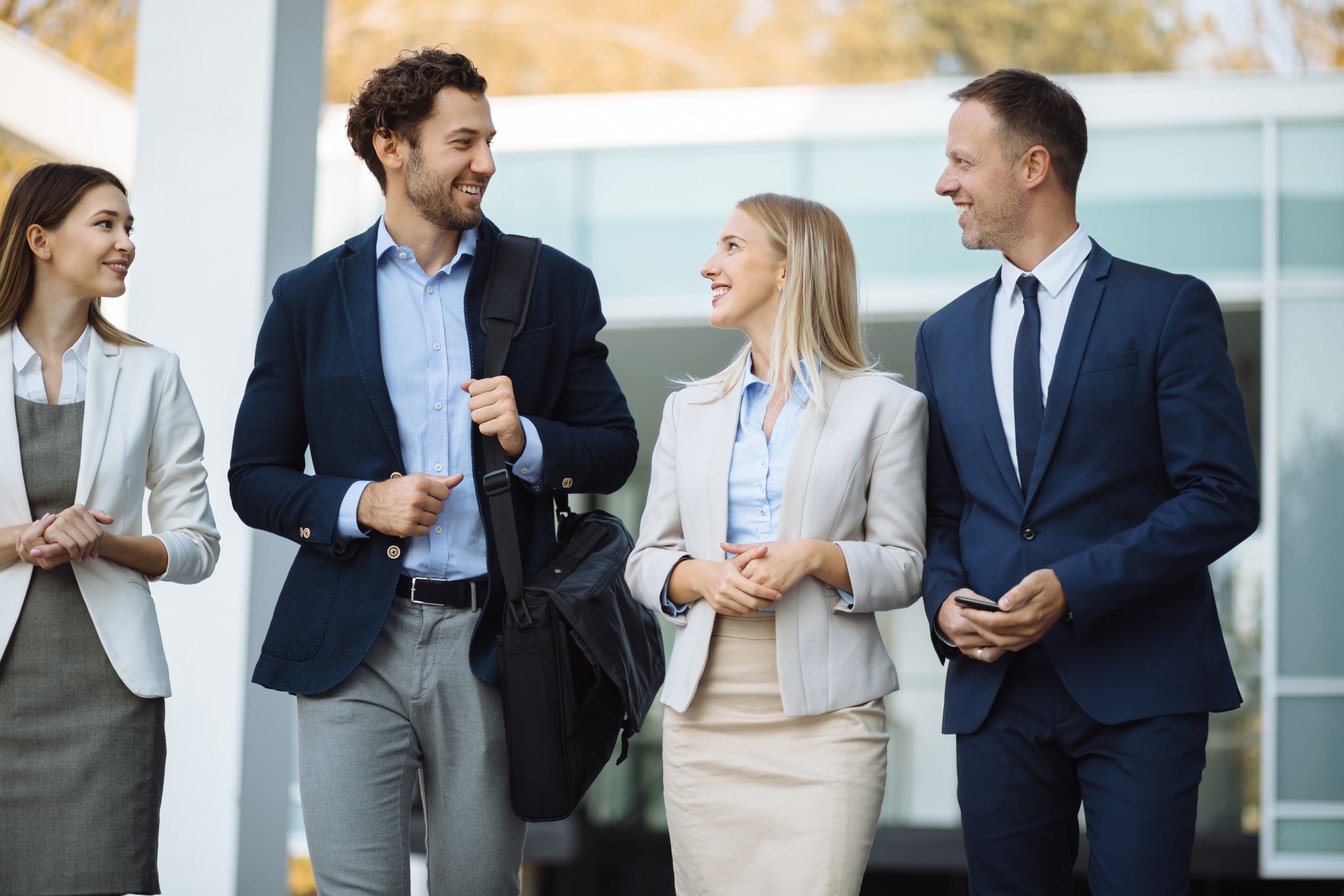 Four young executives talking outdoors